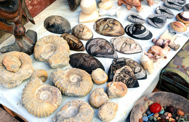 Selection of head masks and ammonite on a traditional Moroccan market (souk) in Marrakech, Morocco