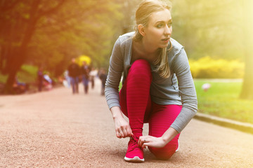 young woman runner tying shoelaces