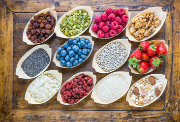Superfood, detox, dieting food.Berries, seeds, nuts, fruits top view on wood background.