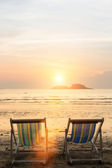 Naklejka premium Sun loungers on the beach during sunset.
