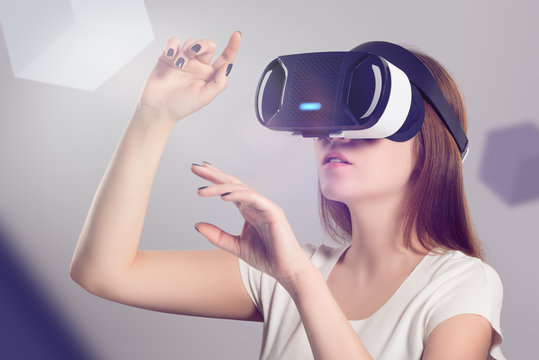Fototapeta Woman in VR headset looking up and trying to touch objects 