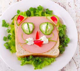 Breakfast with a smiling toast and vegetables.