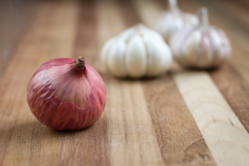 Artistic onion and garlic on wooden table.