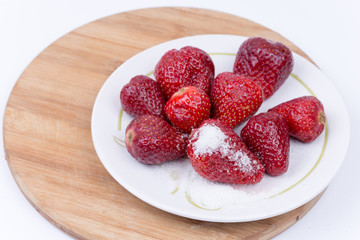 Sugar on the fresh strawberries on the plate