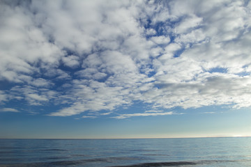 Naklejka na ściany i meble Cloudscape with stratocumulus clouds over horizon