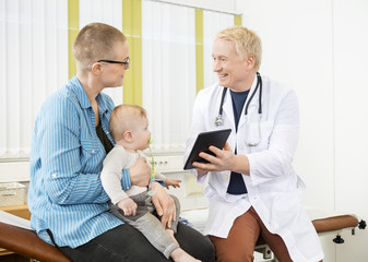 Obraz premium Doctor Showing Digital Tablet To Woman With Baby
