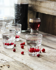 Homemade cranberry vodka, wooden background