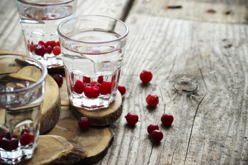 Homemade cranberry vodka, wooden background