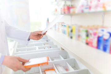 Pharmacist filling prescription in pharmacy - obrazy, fototapety, plakaty