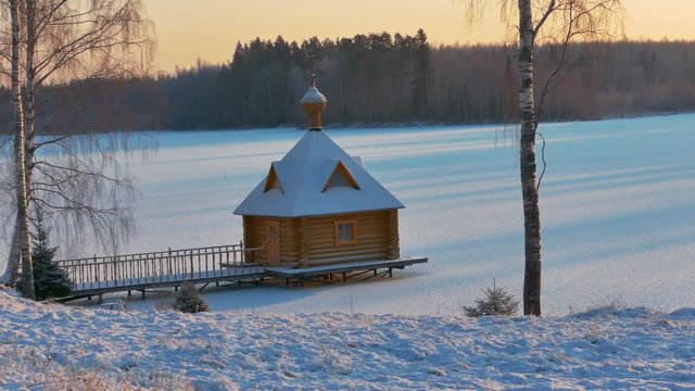 Small Wooden Chapel in a Sunny Snowy Winter Day