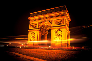 Fototapeta na wymiar triumphal arch paris at night with ray of light coused by moving cars