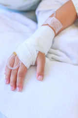 Saline intravenous (iv) drip in a child's patient hand.