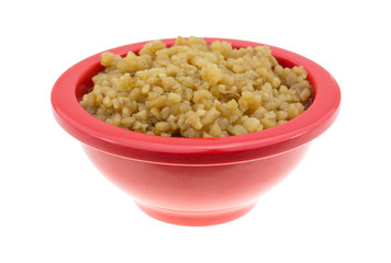 Roasted garlic in a small bowl on a white background