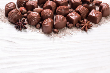 Delicious chocolate candies on wooden background