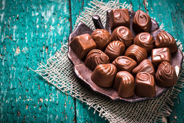 Delicious chocolate candies on wooden background