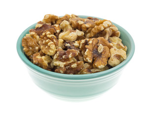 Bowl filled with shelled walnuts on a white background
