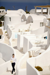 Happy groom with bouquet in the hotel outside