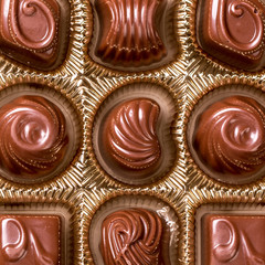 Delicious chocolate candies on wooden background