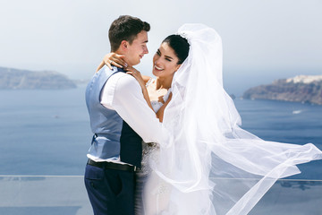 Beautiful newlyweds hugging on sea shore