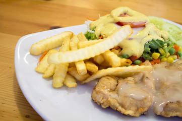 chicken steak with sauce, french fries and salad [blur and select focus background]