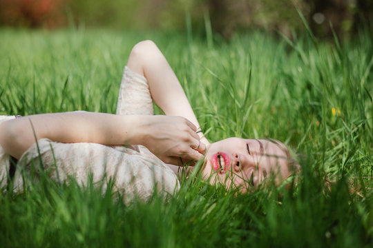 Lovely blonde lying on green grass