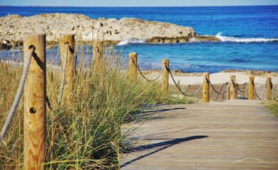 Obraz premium wooden bridge through the dunes to the sea