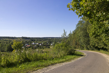 Загородный пейзаж, асфальтовая дорога уходящая вдаль к деревне, лето, солнечная безоблачная погода, голубое небо, одним словом каникулы!