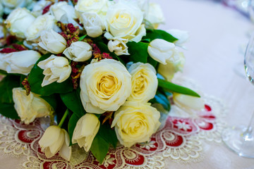 Beautifuly decorated wedding reception table covered with fresh flowers closeup