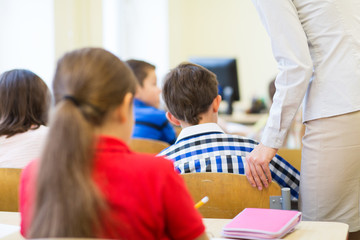 group of school kids and teacher in classroom