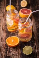 Vitamin water with fruits, refreshment cold drink on wooden background