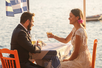 bride and groom drinking wine near the sea