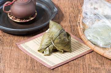 Zongzi on wooden table with cup and Kway
