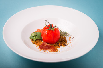 Haute cuisine presentation of false tomate with ham and bread.