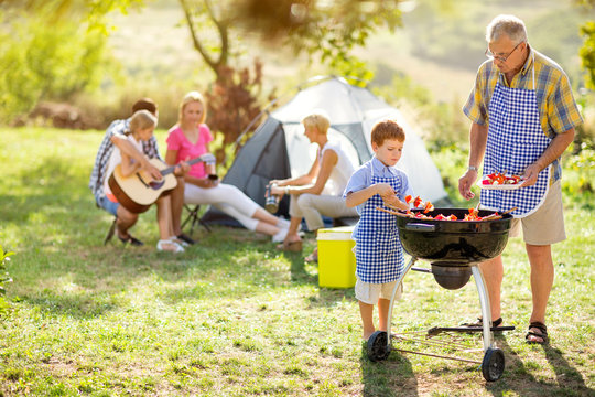 family on camping making barbecue