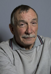 Portrait image of a happy mature man. Studio shot taken on a grey background.