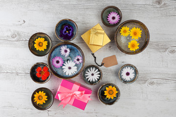 Holiday gifts concept with flowers, gift boxes, and empty tag. Top view with copy space.