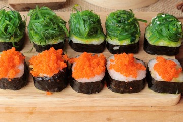 Sushi roll with seaweed salad and shrimp eggs.