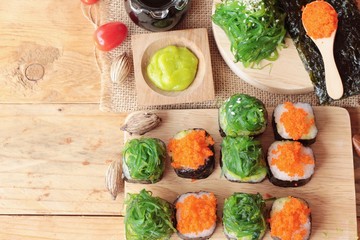 Fototapeta na wymiar Sushi roll with seaweed salad and shrimp eggs.