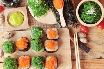 Sushi roll with seaweed salad and shrimp eggs.
