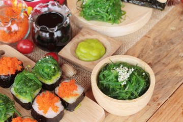 Sushi roll with seaweed salad and shrimp eggs.