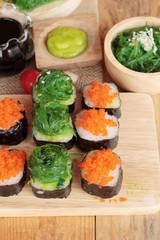 Sushi roll with seaweed salad and shrimp eggs.