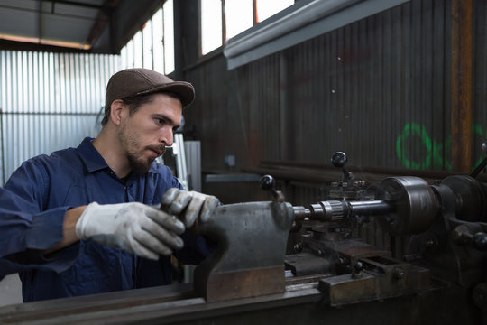 Bearded man working with iron machine
