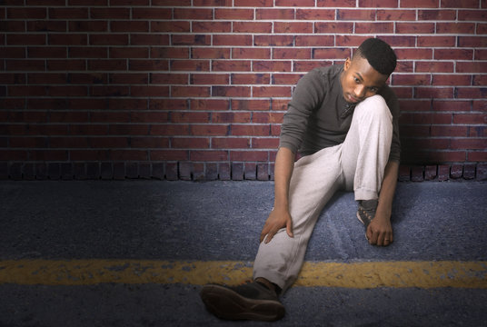 Young Man Sitting On The Ground At Night, Runner In Break
