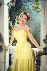 portrait of beautiful elegant young woman in gorgeous yellow evening dress
