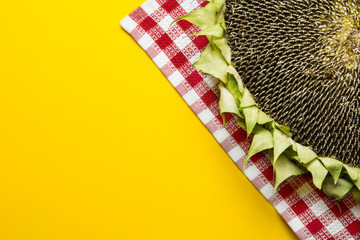 Sunflowers and seeds in bowl on yellow background