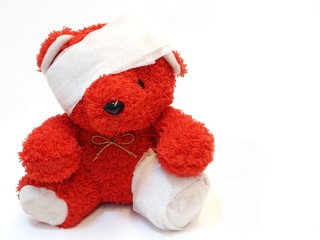 Red teddy bear with bandage over his head and leg with free text 