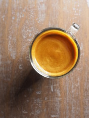 Cup of hot espresso coffee on wood table, background