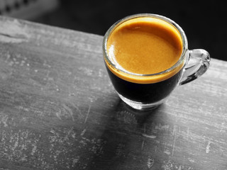 Cup of hot espresso coffee on wood table, background