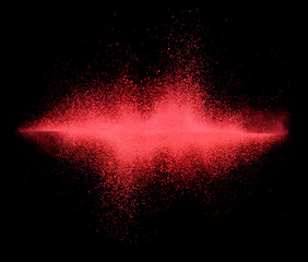 Explosion of red powder on black background