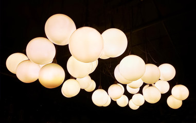 Lighting ball hanging from the ceiling on the black background